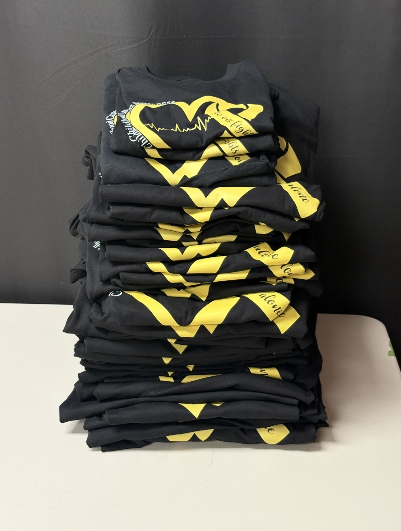 Stack of custom printed shirts by Lori Apgar Creates